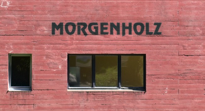 Picture of a facade of a building. The painted text on the the wall spells «Morgenholz».