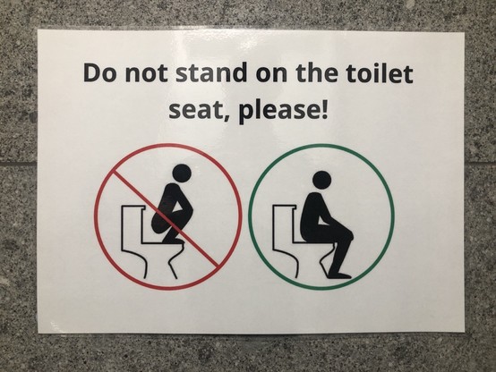 Sign saying „Do not stand on the toilet seat, please“.