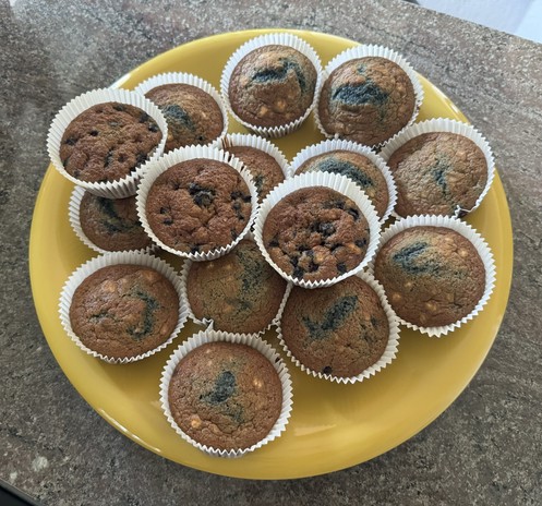 A pile of freshly baked muffins on a yellow plate.