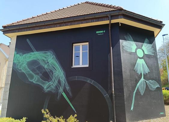 The London artist Shok-1 works on this façade at the intersection of Rue des Envers and Rue Alexis-Marie-Piaget. The mural is rendered in the colour of radium watch lume, as if it were the dial glowing in the dark.