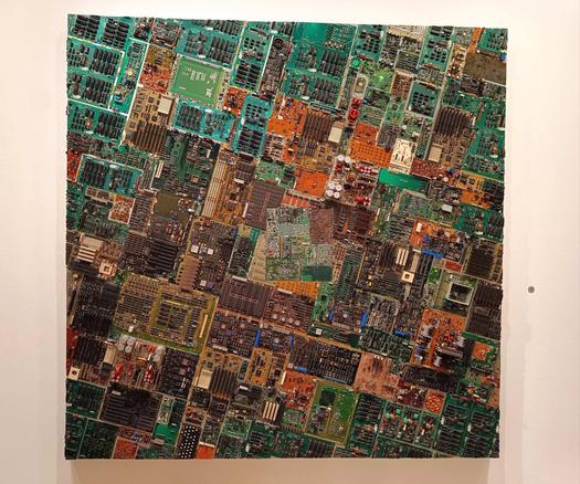 Grossformatiges Wandobjekt. Von weitem sieht es aus wie eine Landschaft, doch es sind Leiterplatten und Nieten auf Aluminium