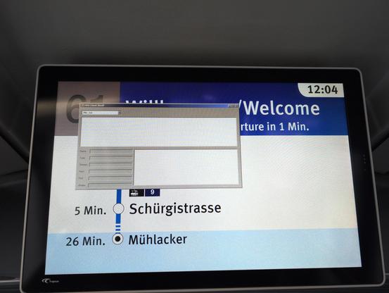 Bildschirm in einem Bus der ZVV. Gezeigt werden die kommenden Haltestellen, grösstenteils aber überlagert ein Dialog die relevanten Informationen. Es ist offensichtlich, dass der Dialog/das System unter Windows läuft.