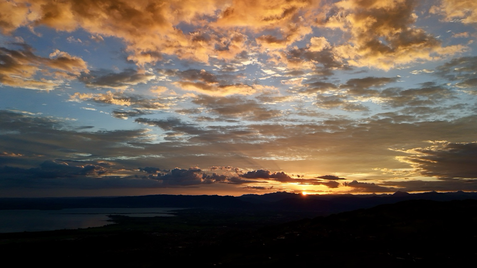 der see ujd das land liegt im dunkeln verschiedene wolkenebenen werden beleuchtet