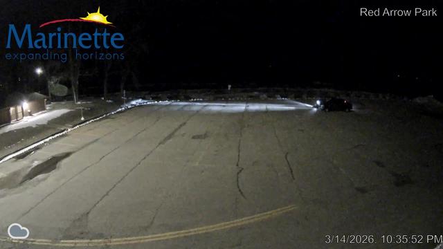 View looking east from Red Arrow Park with a parking lot in the foreground and the shores of Lake Michigan beyond. // Image captured at: 2026-03-15 03:36:02 UTC (about 1 min. prior to this post) // Image sourced from: marinette.wi.us // Current Temp in Marinette: 29 F | -2 C // Precip: overcast clouds // Wind: ESE at 8 mph | 13 kph // Humidity: 74%