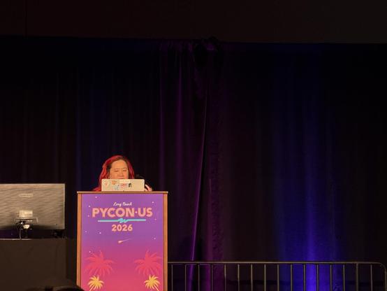 Mariatta on the stage presenting her talk. 