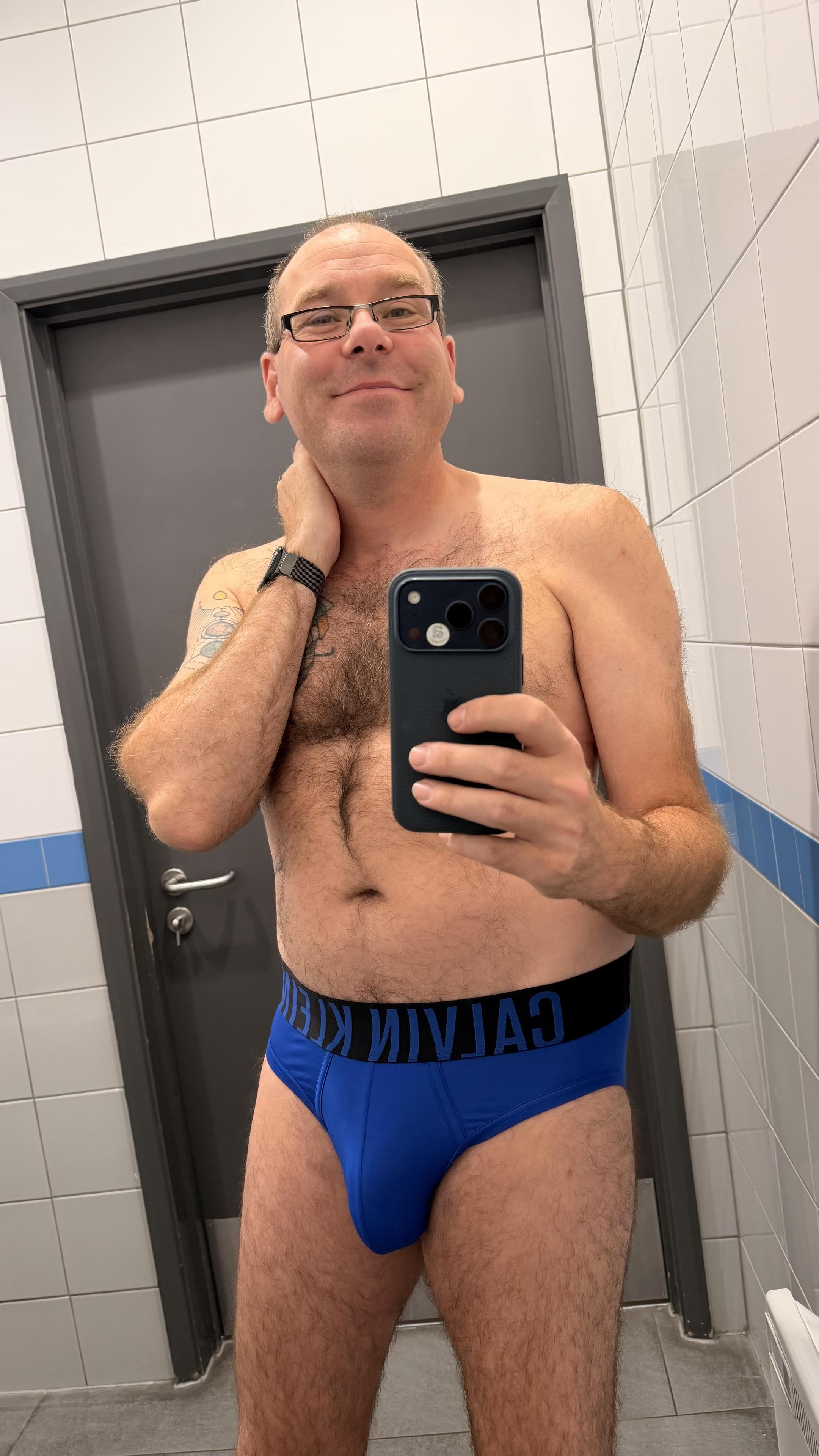 Hairy gay guy wearing blue Calvin Klein briefs with black waistband