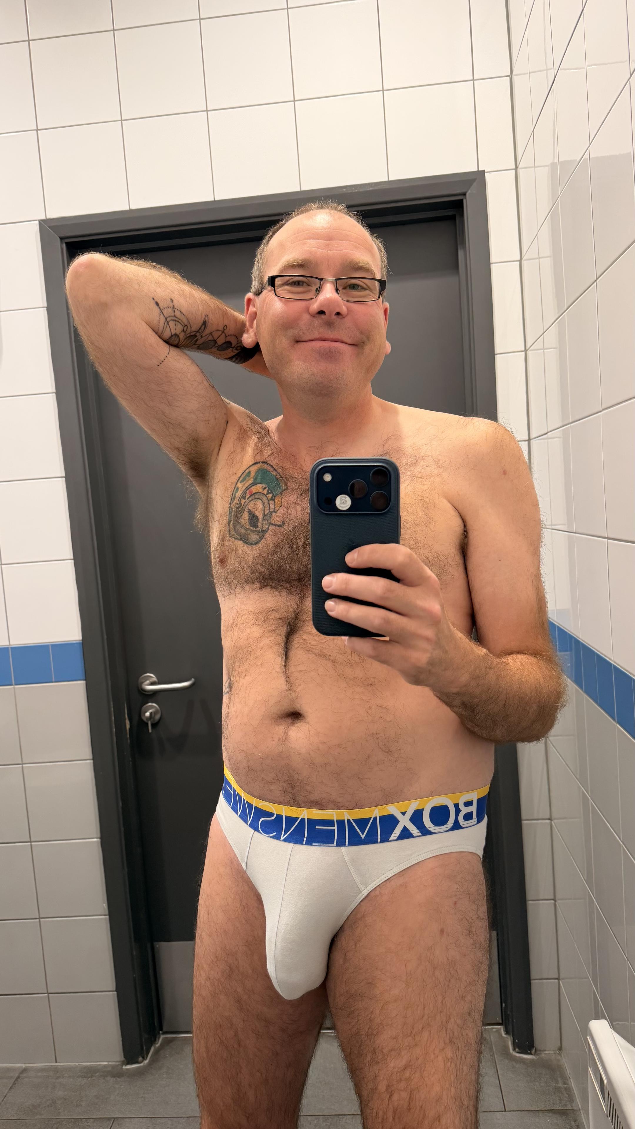 Hairy gay guy wearing white Box briefs with blue and yellow waistband