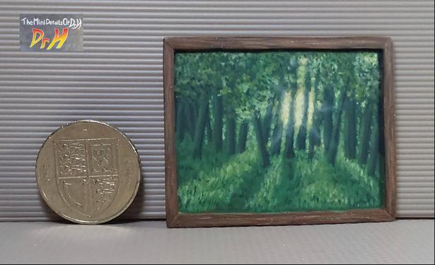 A painting of light shining through trees, and a pound coin for scale.