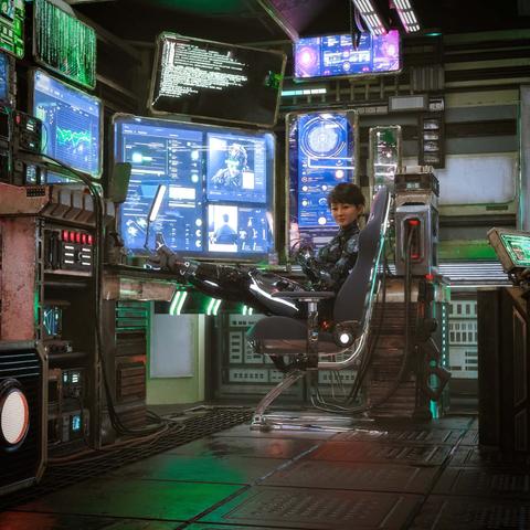 Description by ChatGPT: This image is a highly detailed sci-fi 3D render depicting a young woman in a futuristic control room or hacker den. She reclines comfortably in a sleek, high-tech chair with glowing green lights, her legs casually propped up on a desk. She wears a tight black  armored bodysuit, suggesting she’s either a cybernetic operator, tech-savvy mercenary, or data analyst in a dystopian or spacefaring world. Her short dark hair and confident expression give her a calm, composed demeanor.

The room is filled with dozens of digital screens, each displaying vibrant interface elements in blues, greens, and white text. These include biometric scans, graphs, scrolling code, surveillance feeds, and a large profile image of a person wearing a cyber-helmet. The walls are lined with servers, panels, wires, and tech clutter, giving the space a gritty, lived-in atmosphere.

The lighting is dim, lit mostly by the glow of the monitors and ambient neon accents, creating a moody, high-tech vibe. The scene evokes themes of cyberpunk, espionage, and digital warfare, portraying the woman as fully in control of a sophisticated data network or underground intelligence operation.