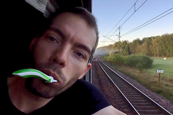 Ich mit Zahnbürste im Mund gucke aus dem Zugfenster