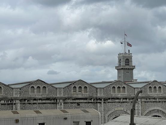 Foto der Navy Base, rechts ragt ein Turm mit Fahnenmast in den bewölkten Himmel.