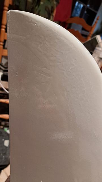 Scraping the paint with a single edge razor can smooth the runs and drips so that they stand only a couple thousandths of an inch (0.05mm) tall. Then they are ready for sanding for final smoothing.