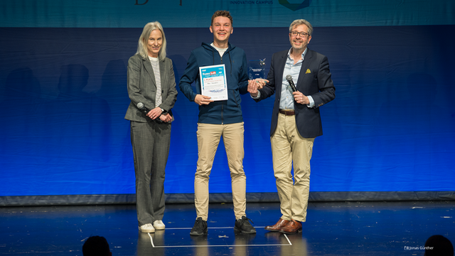 Foto von der Preisverleihung an Artem Govorukhin. Er ist eingerahmt von Marion Schmidt, Chief Communication Officer der TU Dresden und Prof. Gianaurelio Cuniberti, Professor für Materialwissenschaft und Nanotechnik an der TU Dresden.