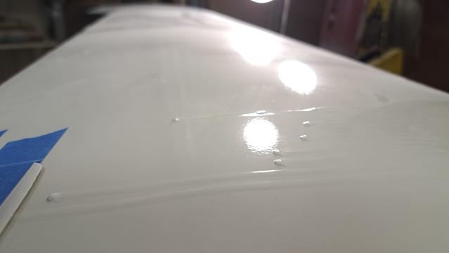 Specular reflections show me many runs and drips that I will scrape down to match the surrounding surface.

(Reflections also show me orange peel...the bane of my existence.)