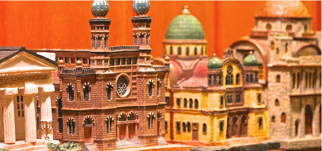 Photo of several ceramic tzedakah boxes in the shapes of beautiful historic synagogues from around the world. 

For more information about tzedakah boxes, see the My Jewish Learning article where this image was found: https://www.myjewishlearning.com/article/tzedakah-box/