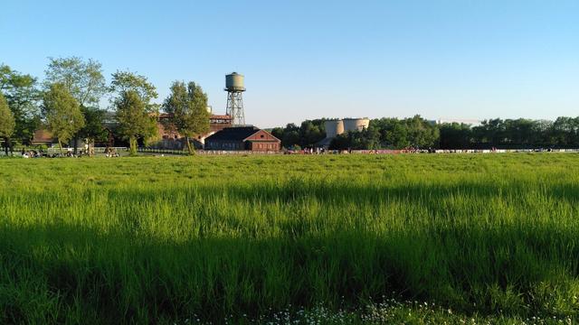 A park, in the back an old factory with water tower.