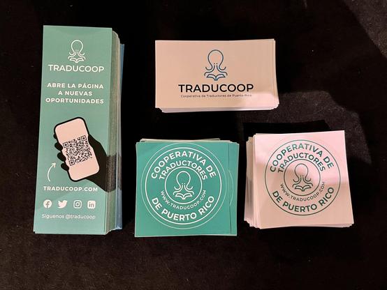 Bookmarks, stickers, and business cards with TRADUCOOP's logo.