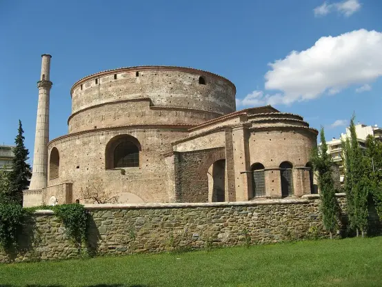 The image depicts a historic architectural structure, which appears to be a round building with a cylindrical shape, likely made of brick or stone. It features a tall column nearby and is surrounded by greenery and a stone wall. The sky is clear with a few clouds. This structure resembles ancient Roman architecture, possibly a temple or monument.

Image Credits: Wikimedia / Filip Maljković from Pancevo, Serbia / CC BY-SA 2.0