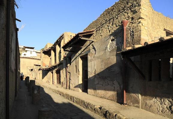 Calle con la entrada de la casa de los muebles carbonizados. Sobre la puerta tiene un pequeño tejadillo.