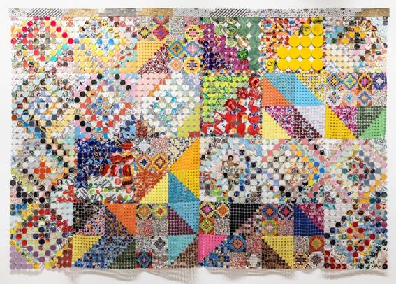 an artwork comprising cloth made from woven and connected pieces of plastic and paper, creating colorful patterns