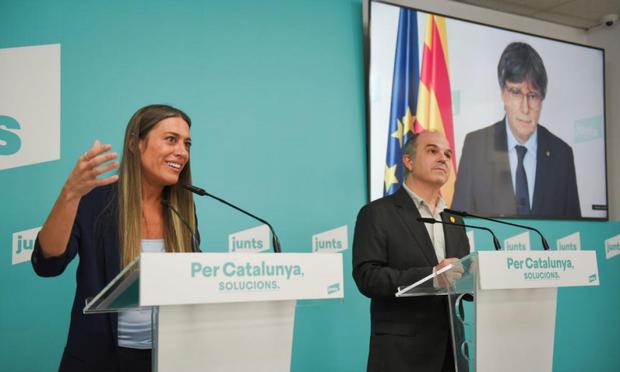 La portavoz parlamentaria de JxCat, Miriam Nogueras, el secretario general de los posconvergentes, Jordi Turull, y el líder de la formación, Carles Puigdemont (en la pantalla); en una imagen de archivo. (Alberto Paredes/Europa Press via Getty Images)