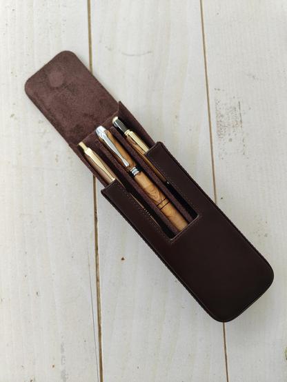 Photo of three handmade wood pens in a leather case.