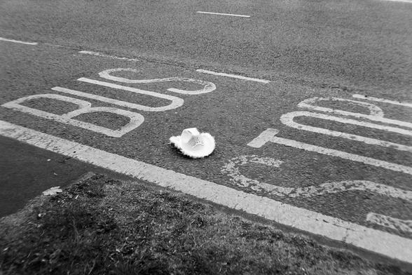 A black and white photograph of a pink cowboy hat at a bus stop in Newcastle.