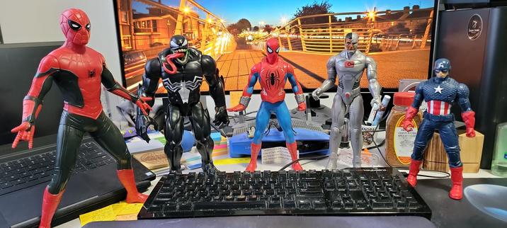 Models of Spider-Man, Venom, Scarlet Spider, Cyborg, & Captain America around my keyboard.
