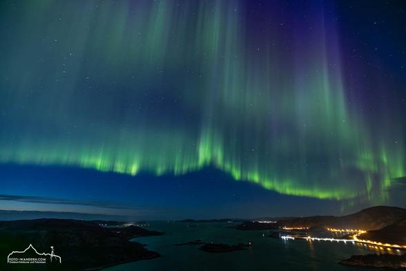 Northern lights and green, blue, and purple colors over the Norwegian Sea.