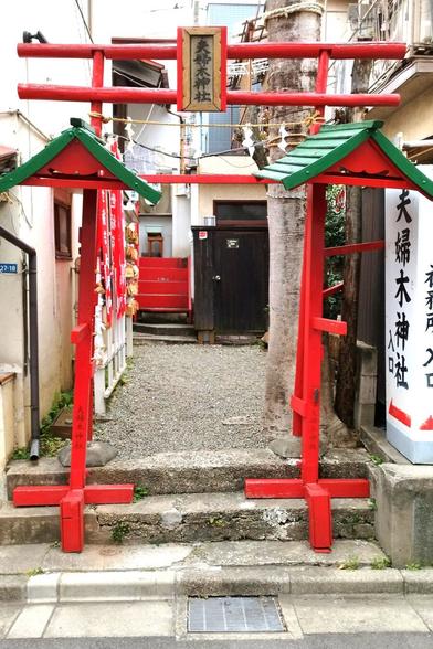 This shrine is located in a building that looks just like all the other buildings here, two-to-three-storey, economic boom era, built tightly next to each other. This gate is in a gap where a couple of steps lead up to a path towards a staircase (presumably to the shrine, I didn't venture that far). The gate is made of wood but thin, round sticks of it were used, which is a rare look. There are two smaller green-tiled roofs stretched on either side but there is nothing underneath to be sheltered.