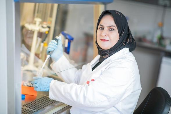 Chemikerin arbeitet im Labor und hält eine Pipette in der Hand. Foto: Christian Kielmann
