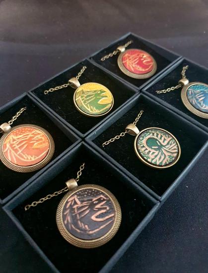 Dragon necklace, brass pendant with a veg tan leather insert and brass chain. Hand-tooled and hand-dyed.