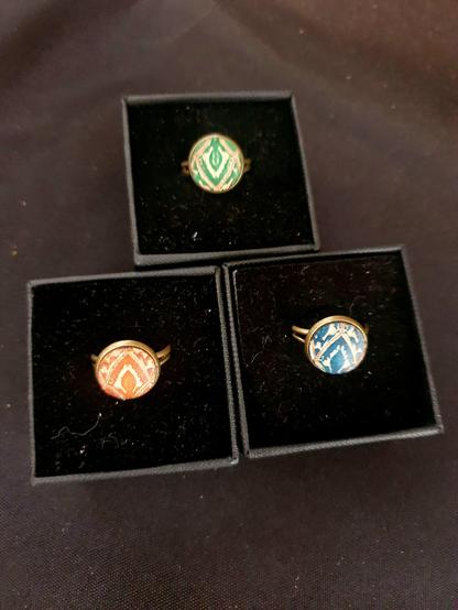 3 Adjustable brass rings with a veg tan leather insert. Hand-stamped and hand-dyed in green, orange and blue.