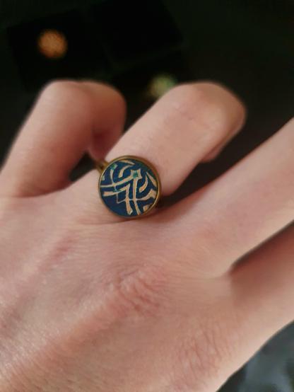 A brass ring with a veg tan blue leather insert on my hand. Hand-stamped and hand-dyed.
