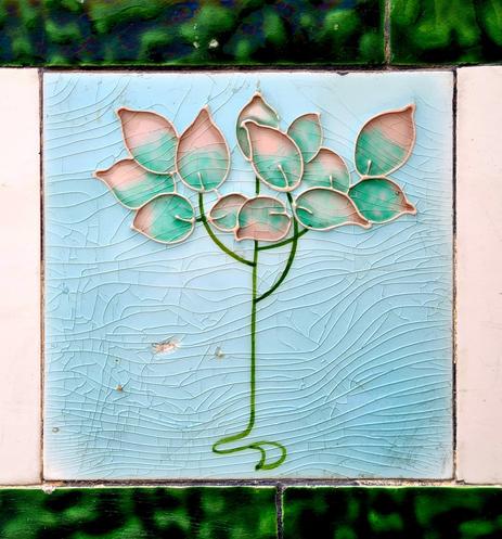 An art nouveau style floral design on a Victorian tile.