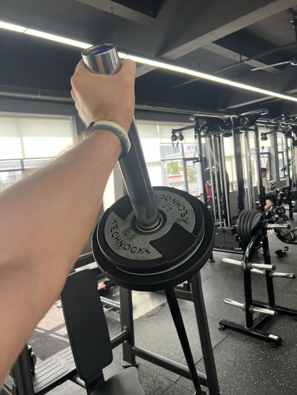 An extended arm holding up a barbell with weights on it