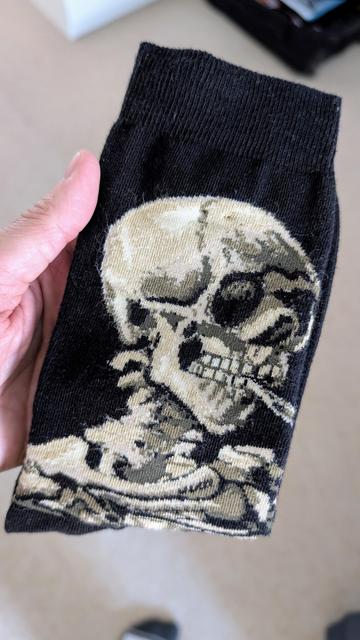 A pair of sock with the skeleton smoking pairing by Van Gogh.