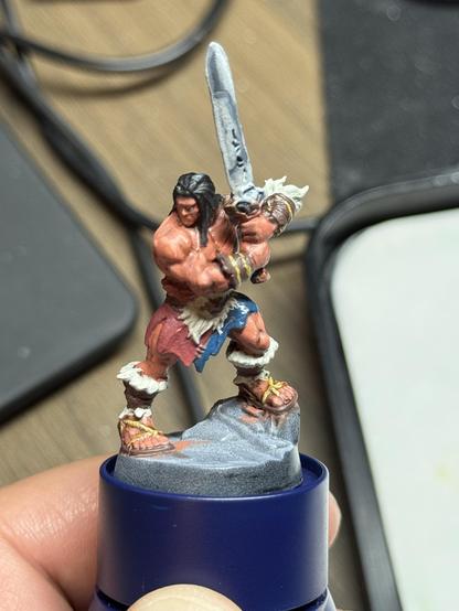The barbarian from the boardgame HeroQuest on a painting handle. The skin now has highlights added to it and the sword was painted with the nmm technique, but needs rework. He is shown off angle from the front.