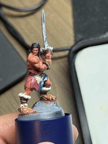 The barbarian from the boardgame HeroQuest on a painting handle. The skin now has highlights added to it and the sword was painted with the nmm technique, but needs rework. The eyes look still a little derpy. He is shown from the front.