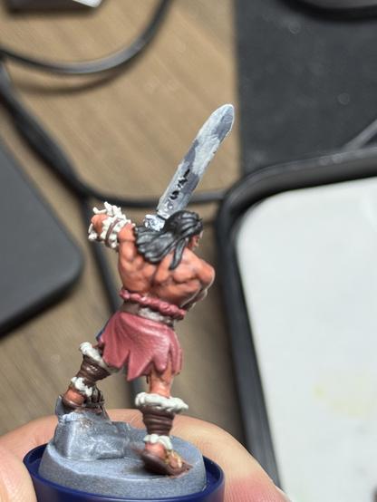 The barbarian from the boardgame HeroQuest on a painting handle. The skin now has highlights added to it and the sword was painted with the nmm technique, but needs rework. He is shown with the back to the camera.