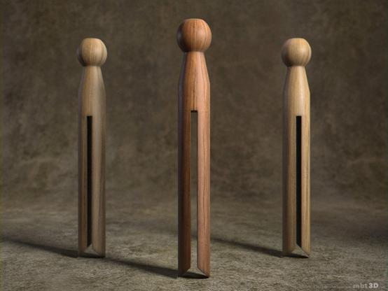 Three old fashioned wood clip pegs standing in a row.