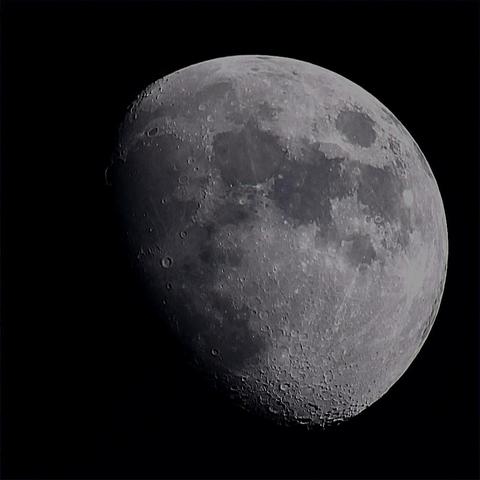 The Moon at waxing gibbous phase on a dark background.