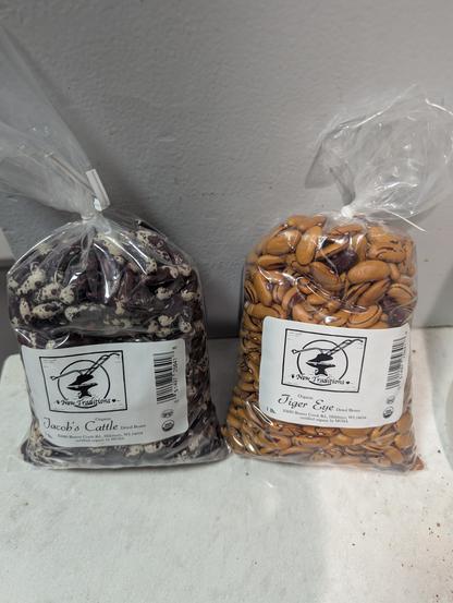 Two one-pound bags of beans. One is labeled Tiger Eye, the other Jacob's Cattle. Both have interesting patterns and colors.