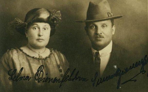 A photo of a woman and a man next to each other. They are visible from their chest up. Both are well-dressed and wear hats. Their signatures are visible in the photo.