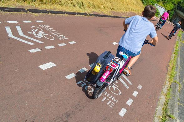 Foto: Dutch Cycling Embassy. Das Foto zeigt einen breiten Radweg mit Kind, das zur Schule radelt