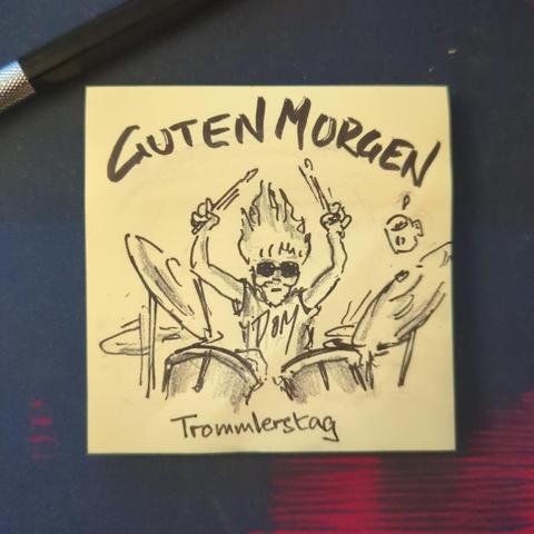 Auf einer gelben Haftnotiz steht "guten morgen"
Darunter ist ein langhaariger, bärtiger Schlagzeuger zu sehen.
Es ist Trommlerstag