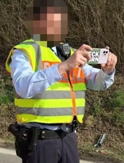 Foto rines Polizisten aus Heilbronn: in gelber Weste mit dickem Bauch macht er mit seinem Handy Fotos: darauf der Aufkleber : Fck Grn Sein Gesicht ist verpixelt