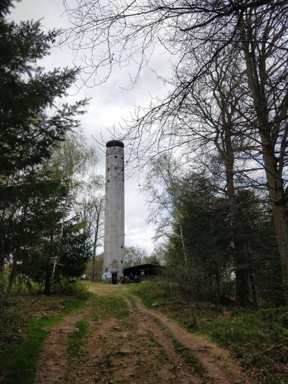 Foto des Mahlbergturm mit danebenstehender Schutzhütte.
Der Turm sieht aus wie eine lange aufrechtstehende Betonröhre mit Fenstern drin. Am unteren Ende wurde der Turm bemalte. Von dem Blickwinkel aus sieht man einen gemalten Hirsch und Schmetterling.