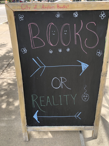 Sign outside bookstore—Books one direction, reality the other