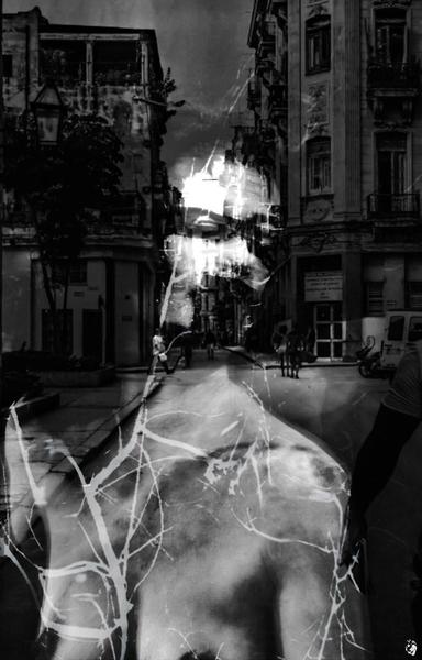 Black and white photograph, portrait format, multiple exposures. Portrait (head and torso, unclothed) of a woman, mouth and eyes painted black, looking to the side. Also illuminated with a canyon of buildings as an architecturally structuring element and water reflections as an ornamental element on the body. Overall impression: dark, oppressive. Contrast between symmetrical and organic elements. Contrast between what is said and what is understood.